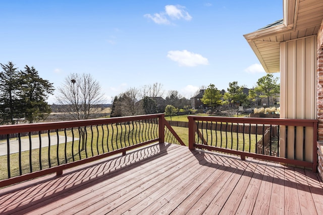 wooden deck featuring a lawn