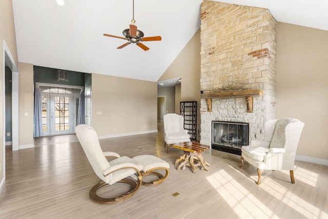 interior space featuring wood-type flooring, a stone fireplace, high vaulted ceiling, and french doors