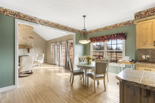 dining room with lofted ceiling and light hardwood / wood-style flooring