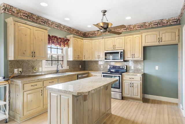 kitchen featuring sink, a center island, light hardwood / wood-style flooring, stainless steel appliances, and backsplash