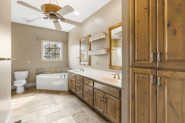 bathroom with vanity, a washtub, ceiling fan, and toilet