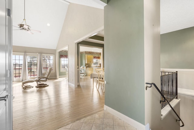 foyer featuring ceiling fan, high vaulted ceiling, and light hardwood / wood-style flooring