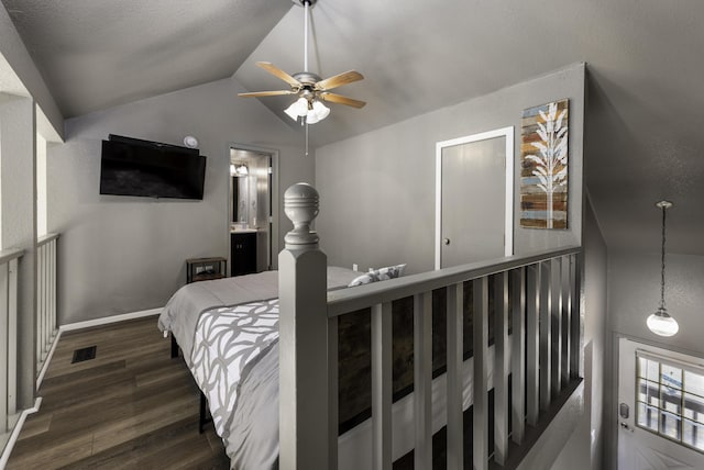 bedroom with dark hardwood / wood-style flooring, connected bathroom, vaulted ceiling, and ceiling fan