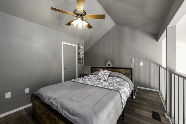 bedroom with vaulted ceiling, dark wood-type flooring, and ceiling fan