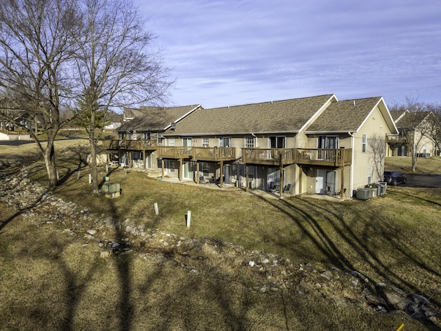 back of house featuring a wooden deck and a yard