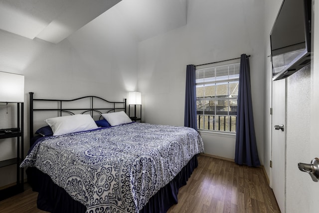 bedroom featuring dark hardwood / wood-style flooring and vaulted ceiling