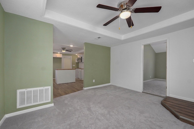 unfurnished living room with a raised ceiling and light carpet