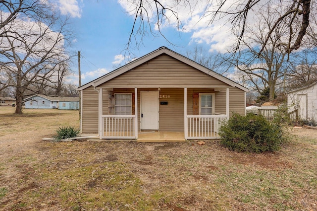 bungalow-style house with covered porch and a front lawn