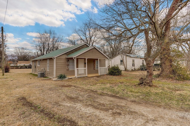 view of front of property with a front yard, covered porch, and central air condition unit