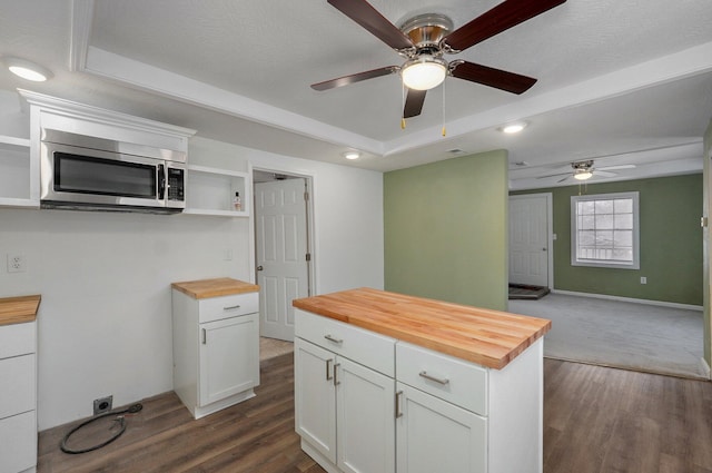 kitchen featuring butcher block countertops, dark wood-type flooring, and white cabinets