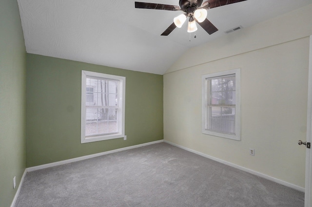 carpeted empty room featuring vaulted ceiling, plenty of natural light, and ceiling fan