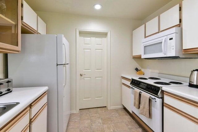 kitchen featuring white appliances and white cabinets