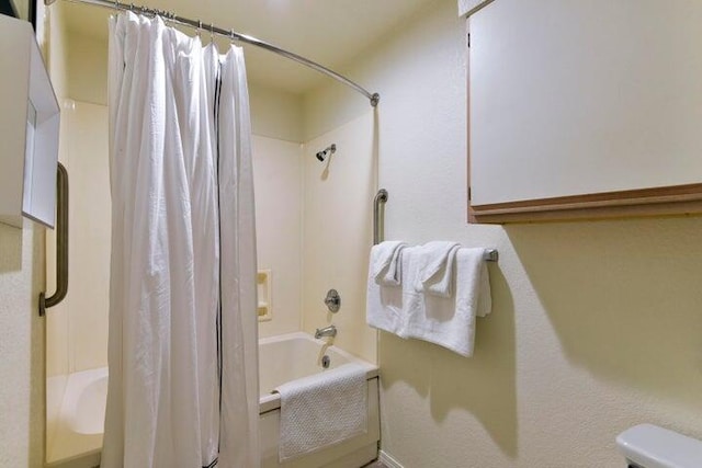 bathroom with toilet and shower / bath combo