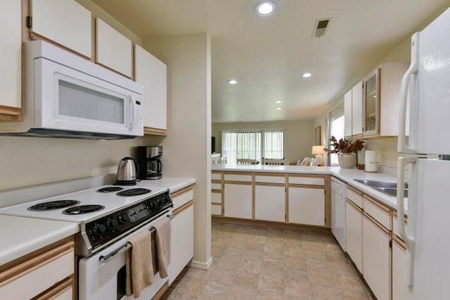 kitchen featuring white cabinetry and white appliances