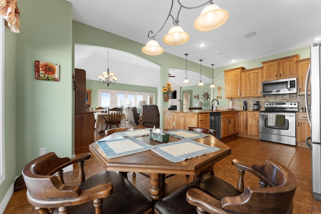 tiled dining space with an inviting chandelier and sink