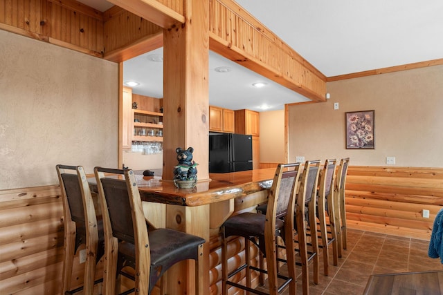 bar with black fridge and rustic walls