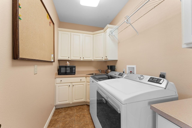 washroom with cabinets, sink, independent washer and dryer, and light tile patterned floors