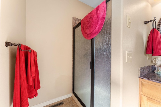 bathroom featuring an enclosed shower, vanity, and tile patterned floors