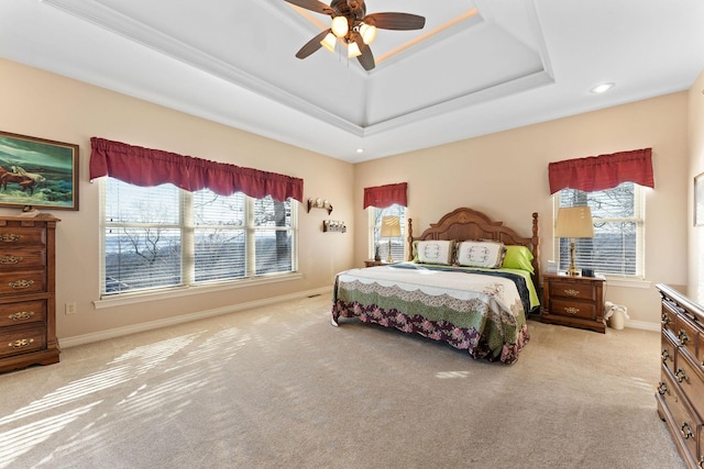 carpeted bedroom featuring a tray ceiling and ceiling fan