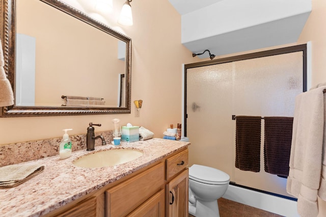 bathroom with vanity, toilet, and a shower with shower door