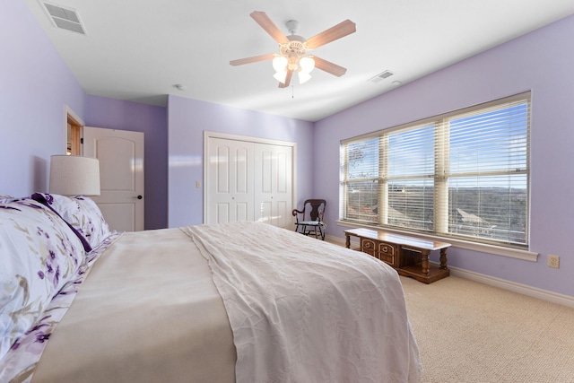 bedroom featuring light colored carpet, ceiling fan, and a closet