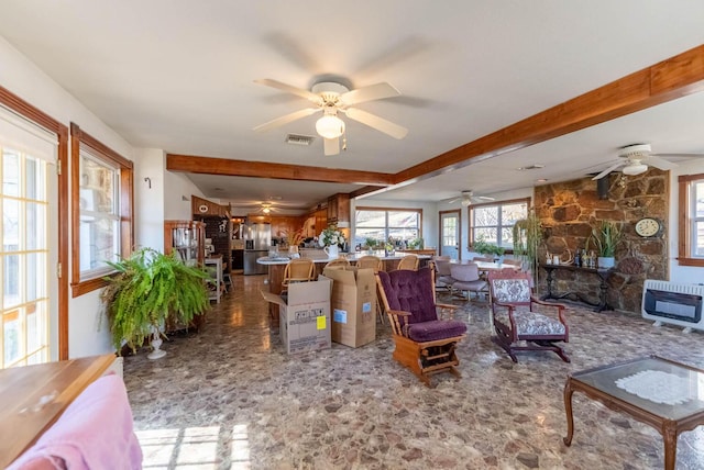 living room with beamed ceiling, heating unit, and ceiling fan