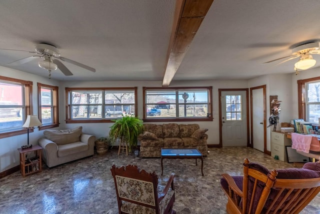 sunroom with ceiling fan and beamed ceiling