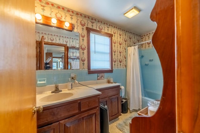 bathroom featuring tile walls, vanity, and shower / tub combo