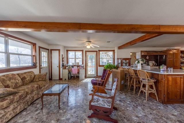 living room featuring beamed ceiling and ceiling fan