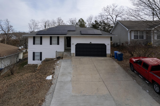 view of front of property featuring a garage and solar panels