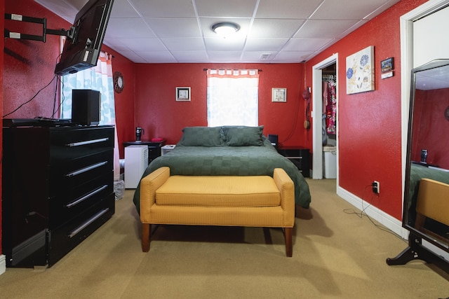 carpeted bedroom featuring a drop ceiling