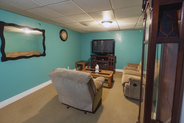 living room featuring carpet flooring and a drop ceiling