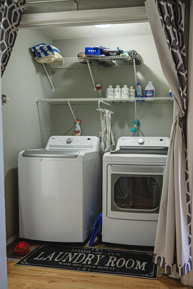 clothes washing area with hardwood / wood-style flooring and separate washer and dryer