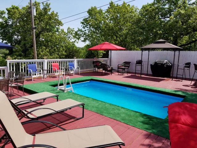 view of swimming pool featuring a gazebo, area for grilling, and a deck