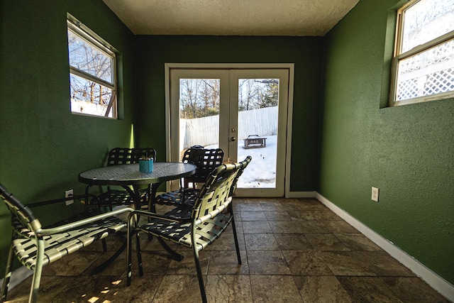 dining space with a textured ceiling and french doors