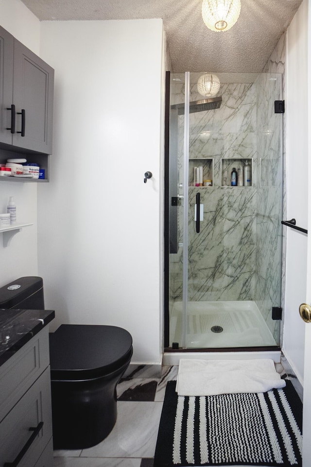 bathroom featuring vanity, toilet, a textured ceiling, and a shower with shower door