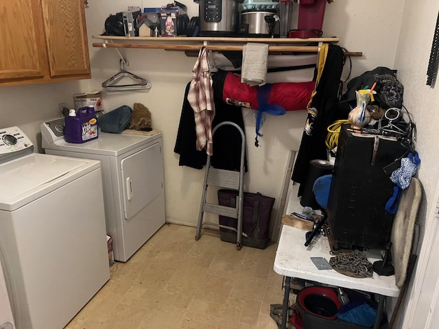 clothes washing area with cabinets and washing machine and dryer