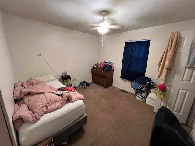 bedroom featuring ceiling fan, carpet floors, and a textured ceiling