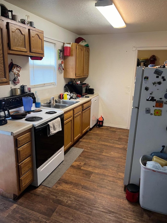 kitchen featuring dark hardwood / wood-style floors, a textured ceiling, and white appliances