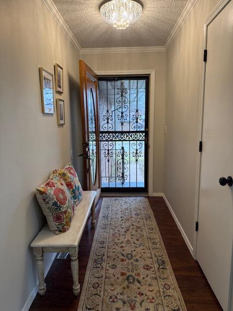 entryway with ornamental molding, dark hardwood / wood-style floors, and a textured ceiling