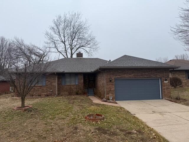 single story home featuring a garage and a front yard