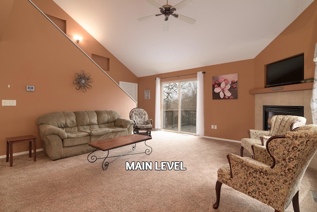 living room with ceiling fan, a tiled fireplace, high vaulted ceiling, and light carpet