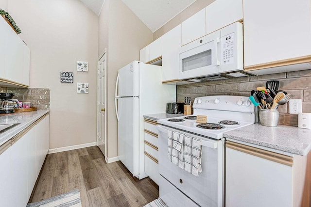 kitchen featuring light hardwood / wood-style floors, white cabinets, white appliances, and decorative backsplash