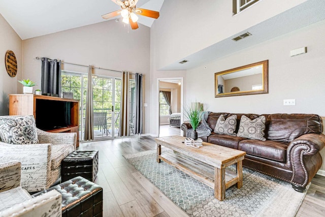 living room with ceiling fan, high vaulted ceiling, and light hardwood / wood-style floors