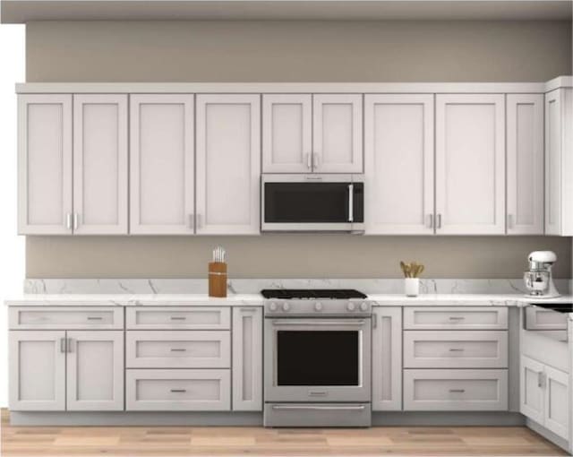 654 Walkington Ln, Branson, MO 65616 - kitchen featuring appliances with stainless steel finishes, light wood-style flooring, and light stone counters