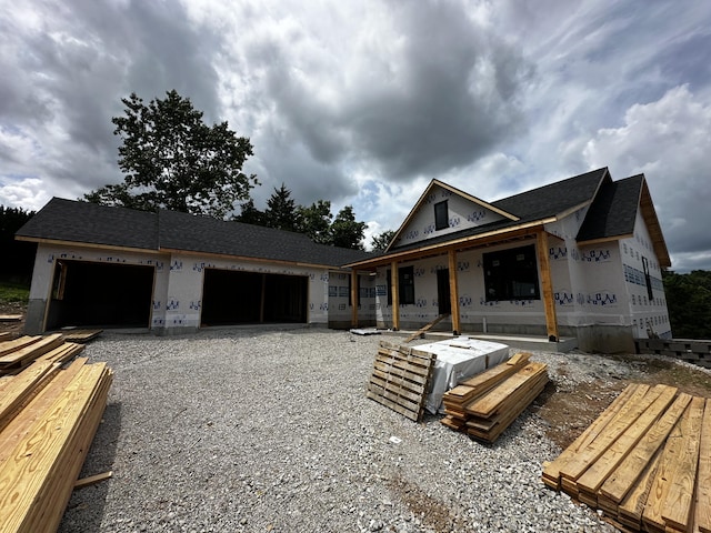 654 Walkington Ln, Branson, MO 65616 - unfinished property with gravel driveway, an attached garage, and roof with shingles