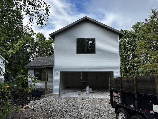 121 Shawn Rd, Kirbyville, MO 65679 - view of side of home with an attached garage, a patio, gravel driveway, and roof with shingles
