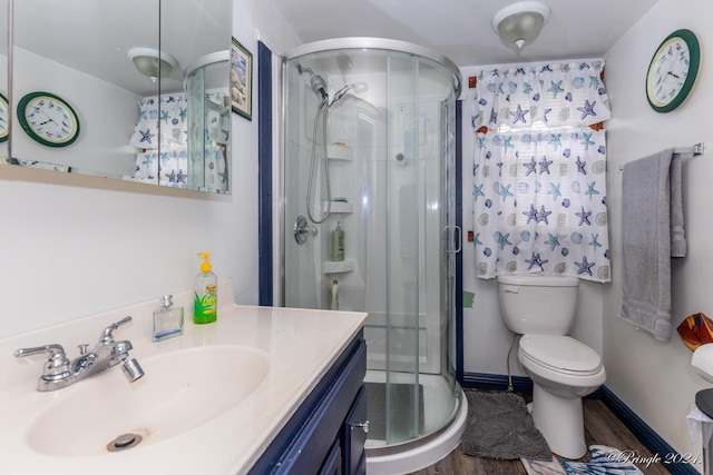 bathroom with a shower with door, vanity, hardwood / wood-style floors, and toilet