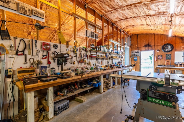 interior space featuring vaulted ceiling, a workshop area, and concrete floors