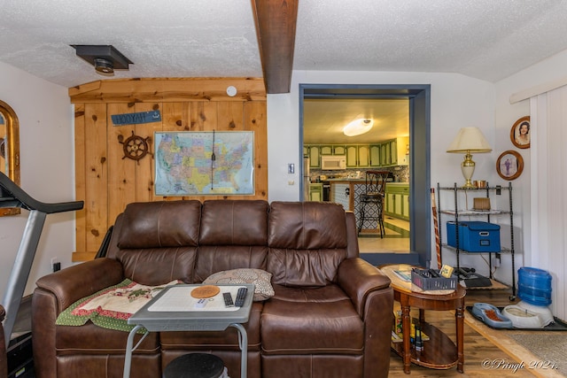 living room featuring wood-type flooring, vaulted ceiling, and a textured ceiling